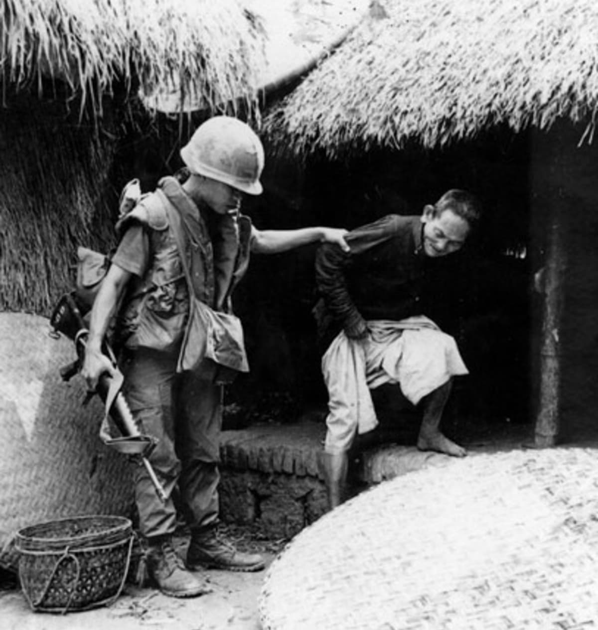 Příslušník roty C v My Lai vyvádí vietnamského muže z domu