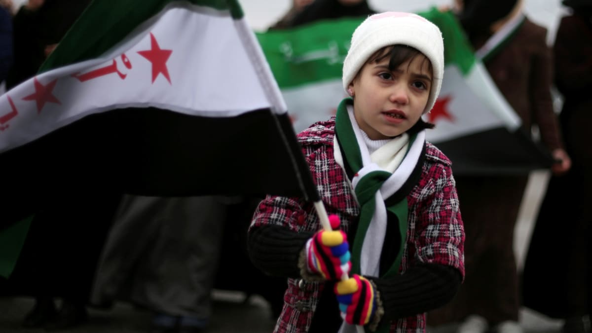 Malá dívka s vlajkou při 31. výročí masakru ve městě Hamá