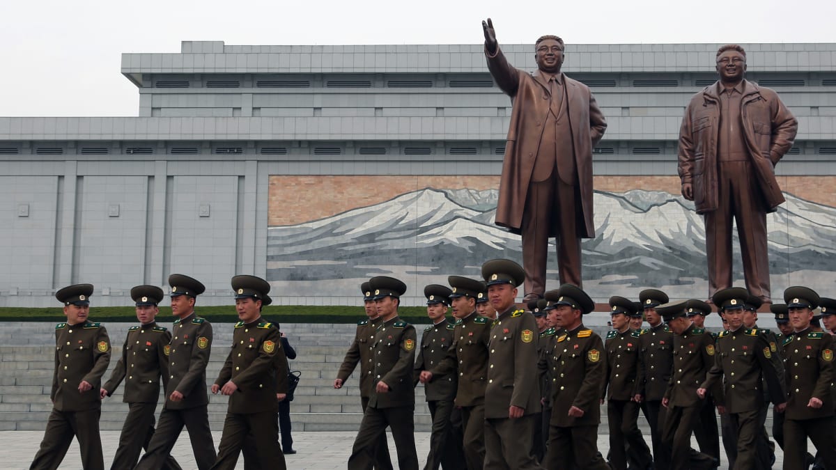 Vojáci u památníku dynastie Kimů – vlevo socha Kim Ir-sena