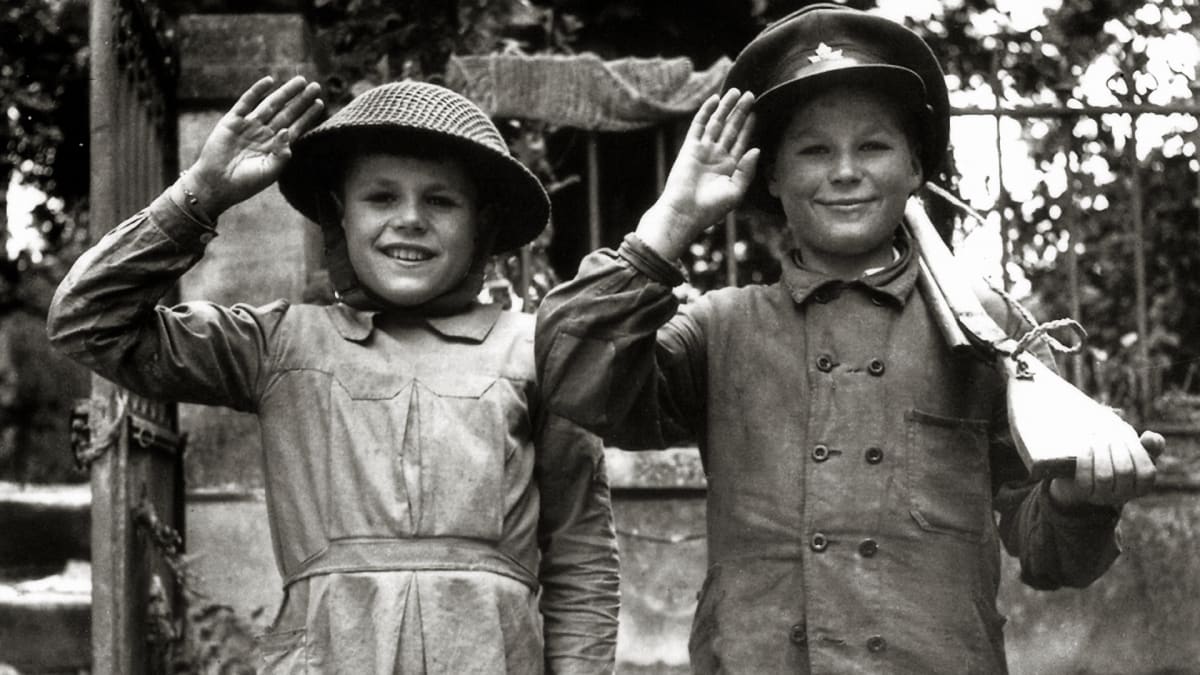 Francouzské děti s kanadskou helmou a čepicí (Caen, červen 1944)