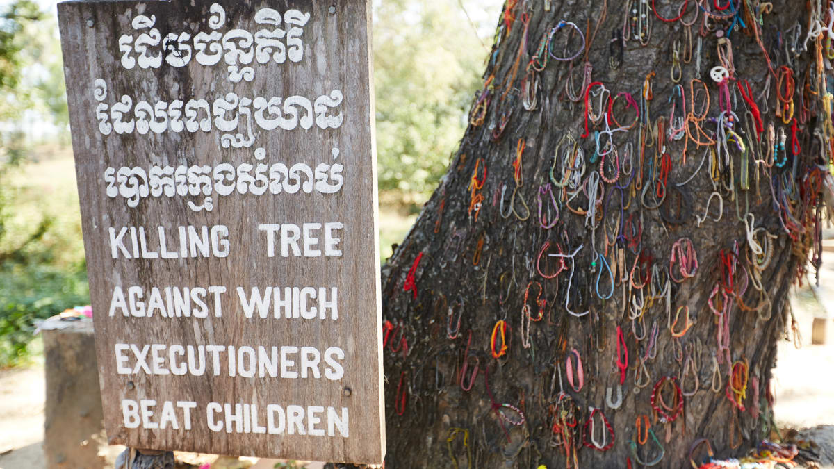 Nápis u stromu, kde Rudí Khmérové často mučili děti