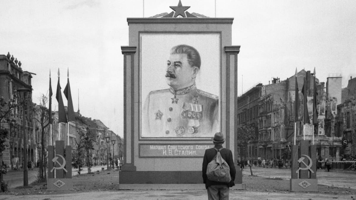 Německý civilista v červnu 1945 nevěřícně zírá na Stalinův portrét na hlavní berlínské třídě Unter den Linden