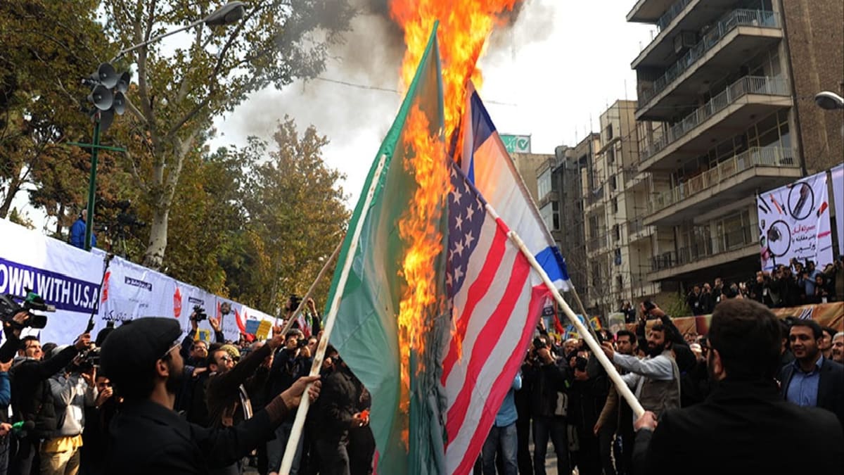 Demonstranti v Teheránu pálí vlajky USA, Saúdské Arábie a Izraele v listopadu 2015