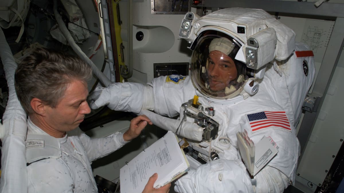 Thomas Reiter (vlevo) kontroluje skafandr velitele mise Jeffreyho N. Williamse na ISS