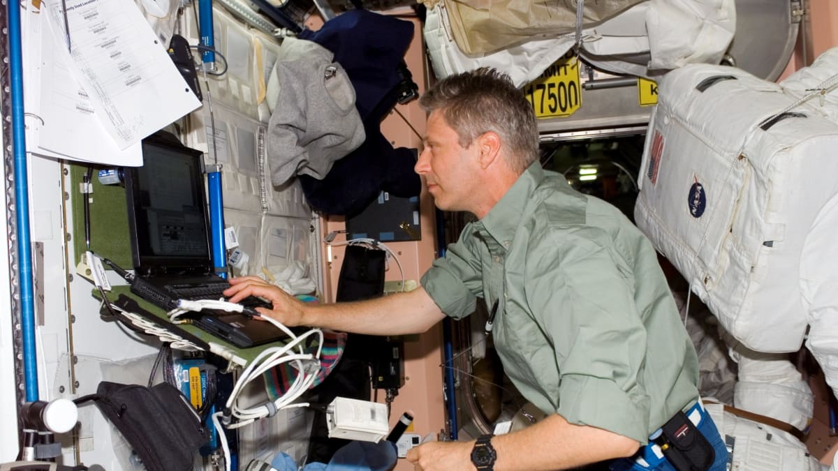 Thomas Reiter pracuje s počítačem uvnitř modulu Unity na ISS