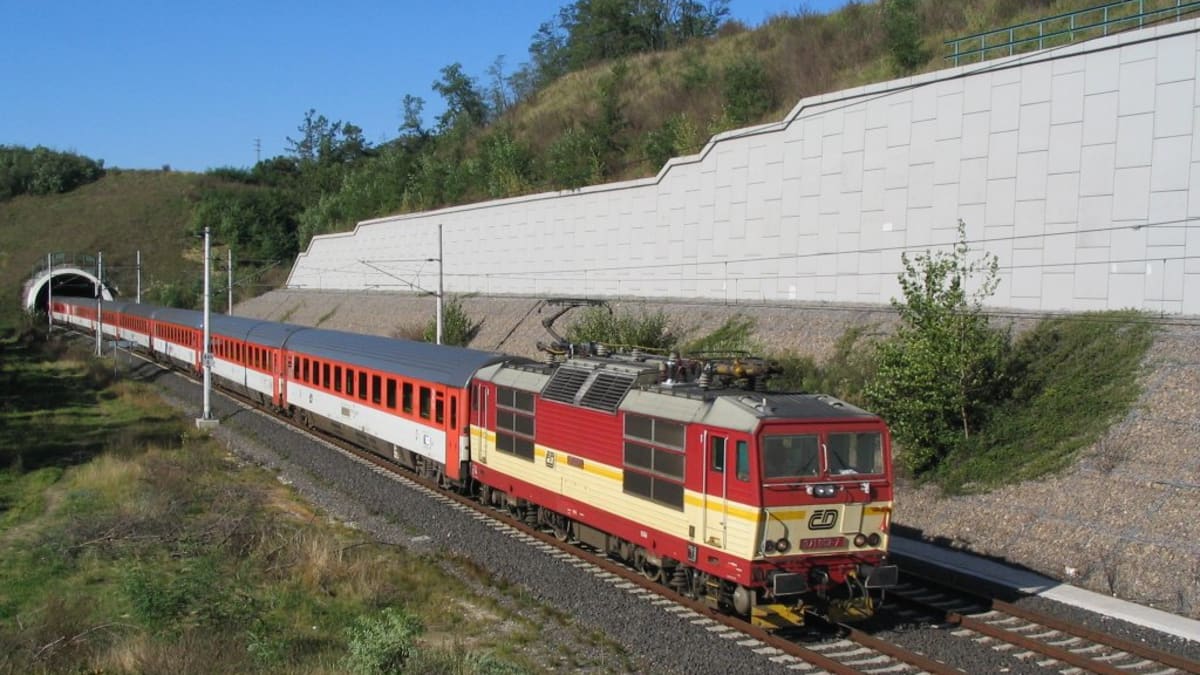 Vlak vyjíždějící z tunelu v čele s lokomotivou řady 371 ČD