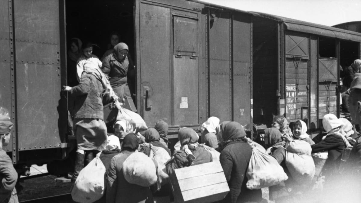 Ženy a dívky odvážené na nucenou práci do Německé říše nastupují pod dozorem do vagonu. Snímky pořídil fotograf propagandistické jednotky wehrmachtu. Ukrajina, jaro 1943.