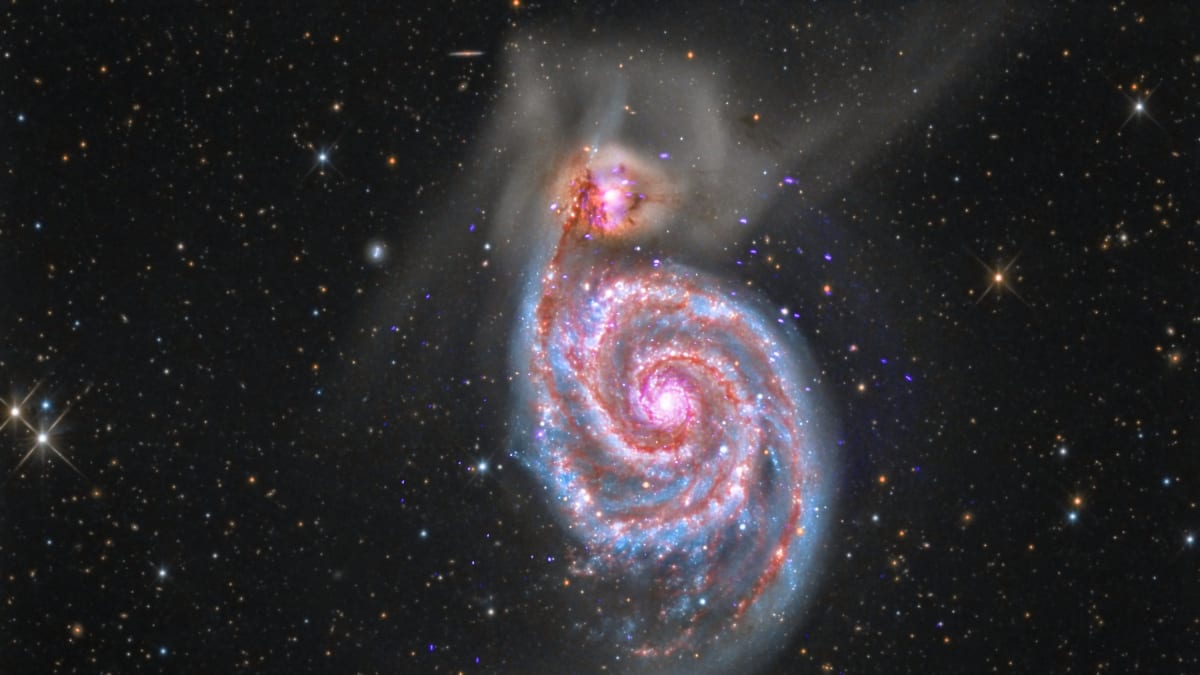 Spirálová galexie M51 se právě spojuje s menší galaxií (nahoře)