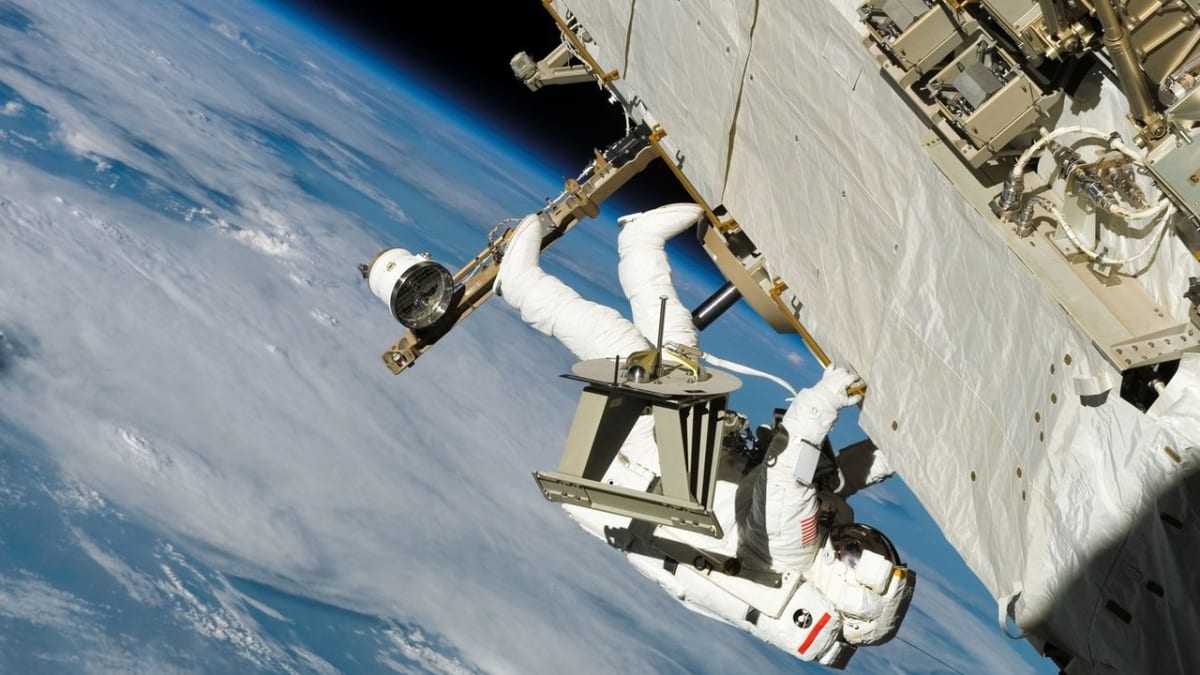 ISS s astronautem na vnějším plášti