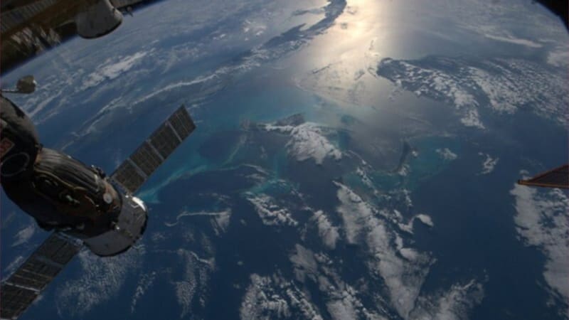 Vesmírná pohoda: Thomas Marsburn zachytil z ISS část stanice a pod ní oblaka nad Karibikem.