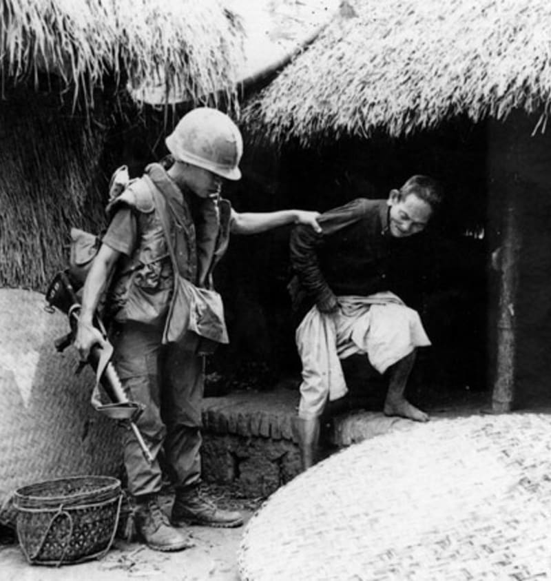 Příslušník roty C v My Lai vyvádí vietnamského muže z domu