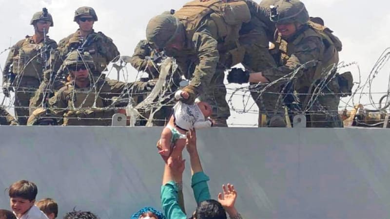 Zoufalí Afghánci házejí batolata přes ostnatý drát vojákům. Reportérka popsala hrůzy z Kábulu