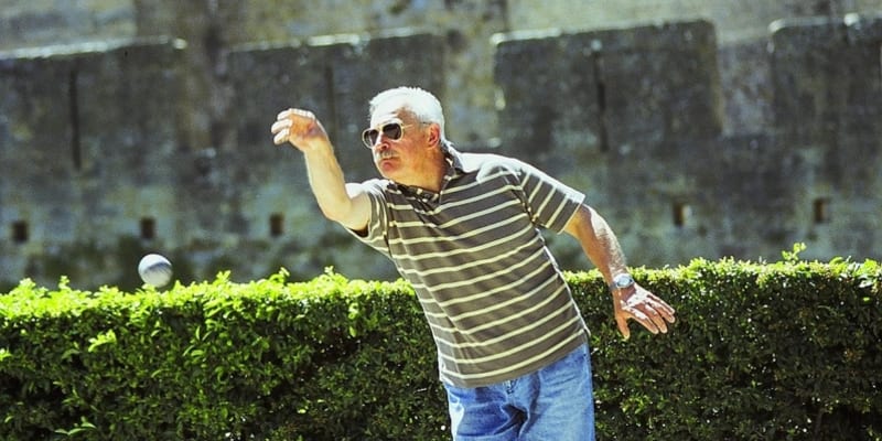 Spokojený Francouz hrající před hradbami Carcassonne petanque