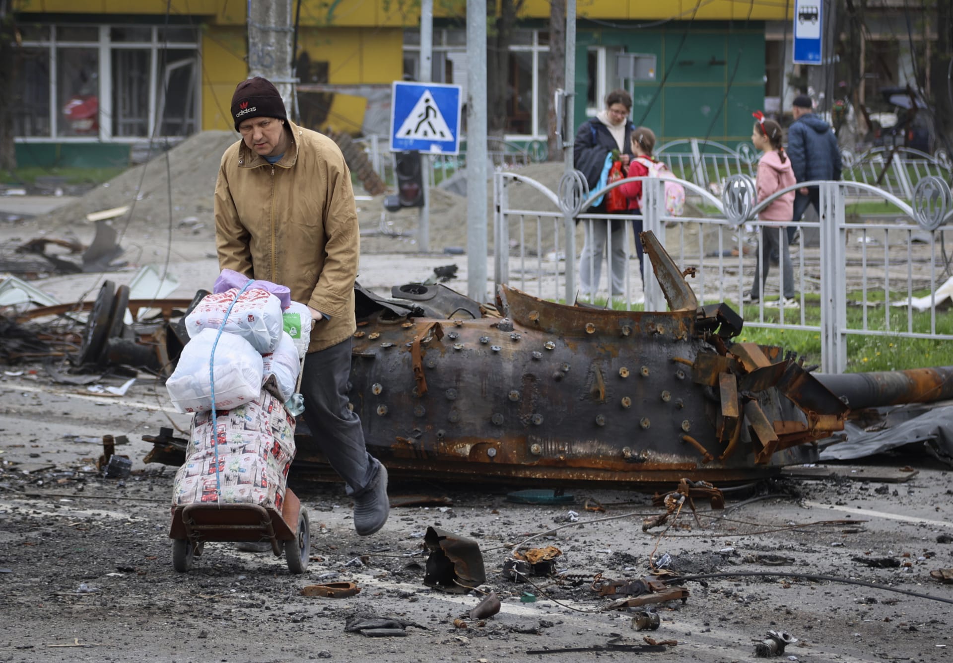 Obyvatel Mariupolu prochází kolem vraku zničeného tanku.