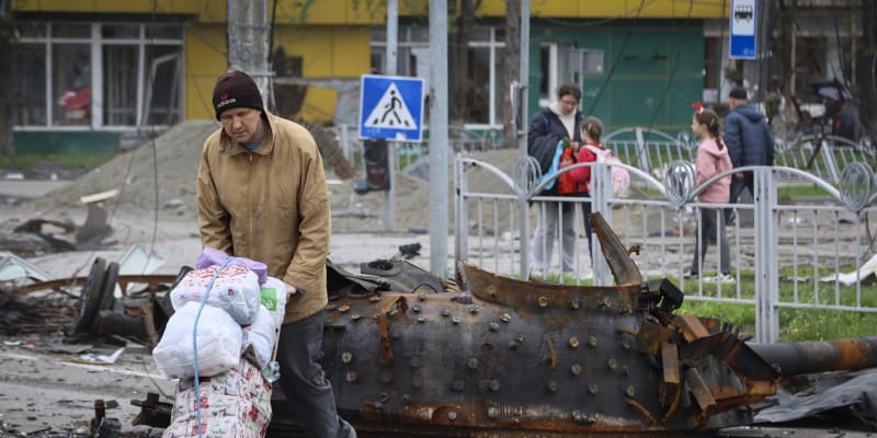 Obyvatel Mariupolu prochází kolem vraku zničeného tanku. (23. dubna)