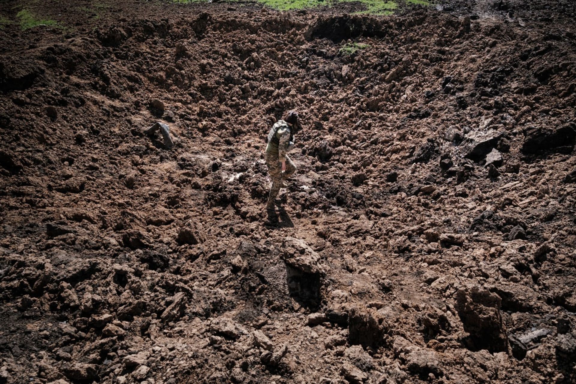 Ukrajinský voják prohlíží kráter po ruské raketě nedaleko obce Bohodarove na východě Ukrajiny.