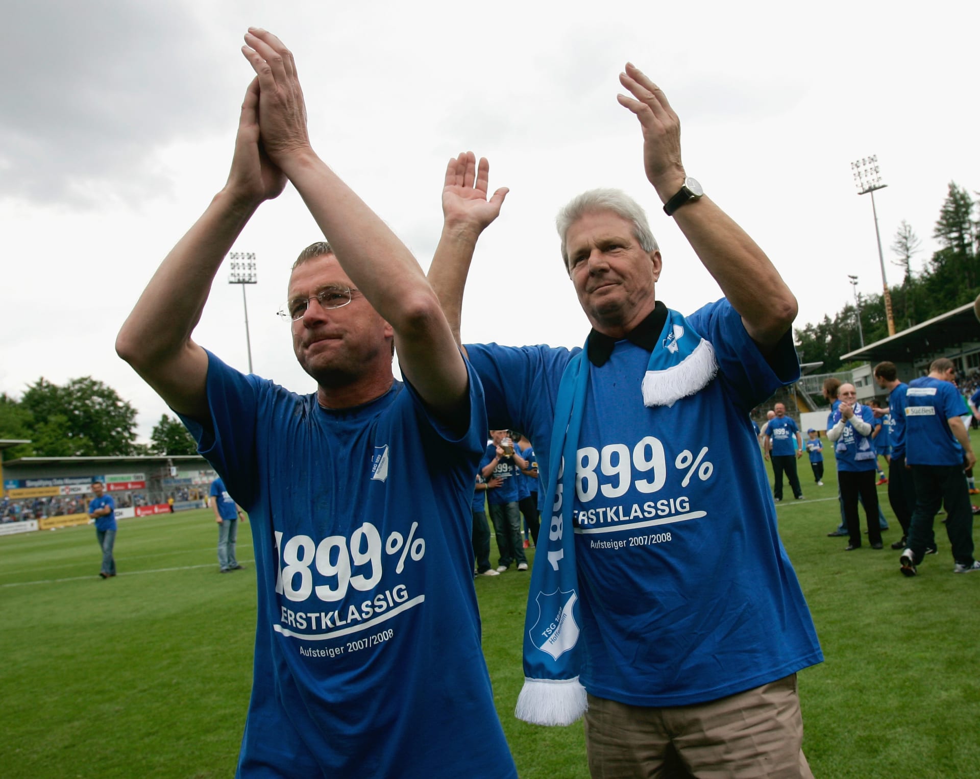 Ralf Rangnick (vlevo) tleská společně s Dietmarem Hoppem, spolumajitelem koncernu SAP a mecenášem klubu TSG 1899 Hoffenheim, fanouškům po postupu do první německé bundesligy v roce 2008. 