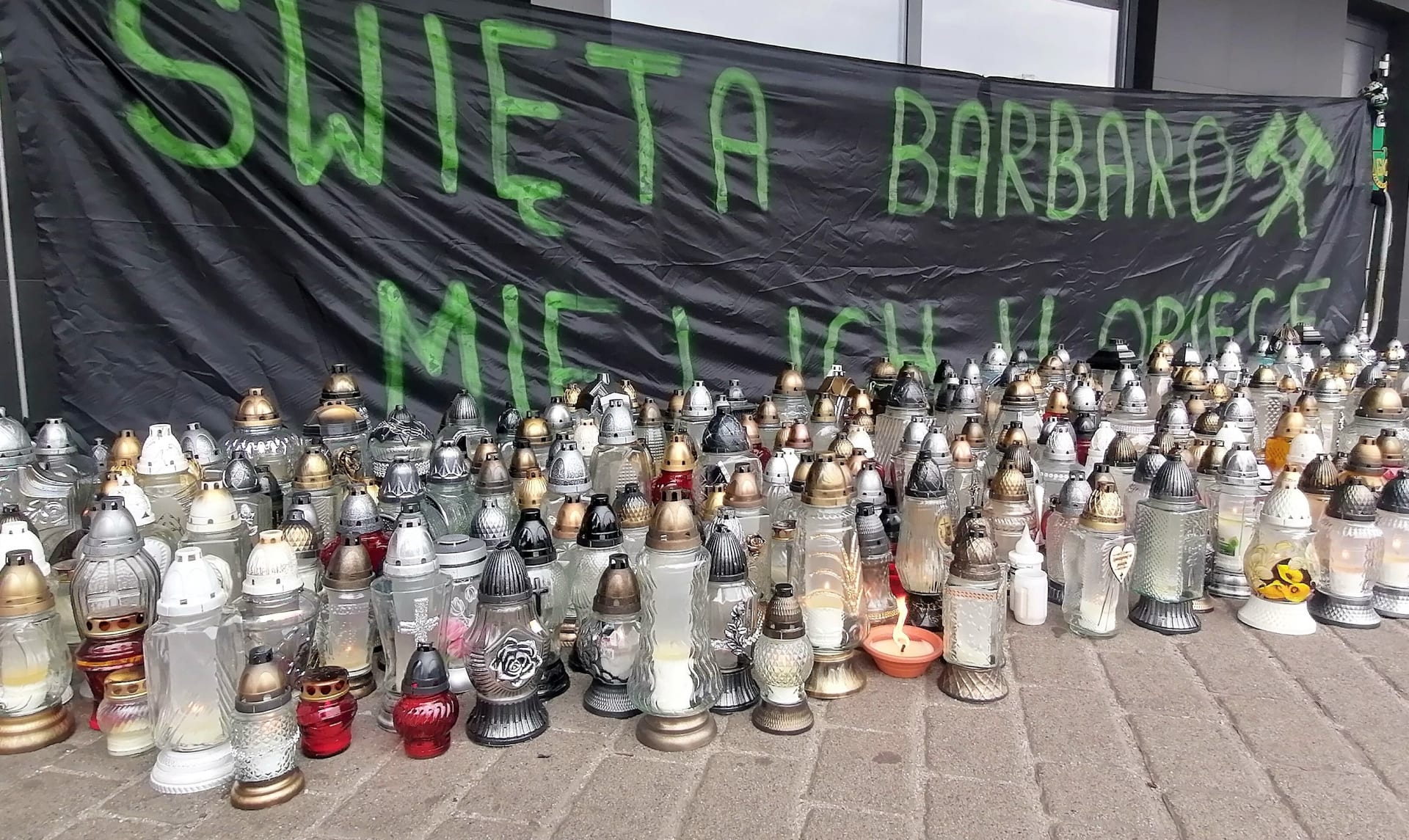Havíř Karol Gdula zapaluje svíčku za oběti výbuchu na Dole Pniówek nedaleko českých hranic. Výbuchy metanu a důlní otřesy  na šachtách Pniówek a Zófiowka si do pátku vyžádaly 26 obětí.
