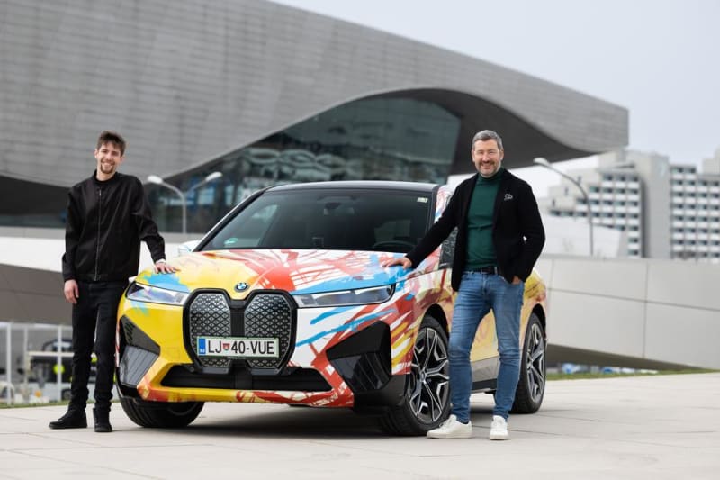 BMW iX v barevné kamufláži od slovinského designera Urbana Klinkona, vítěze soutěže BMW pro mladé umělce. Na snímku s šéfdesignerem BMW Domagojem Dukecem (vpravo).