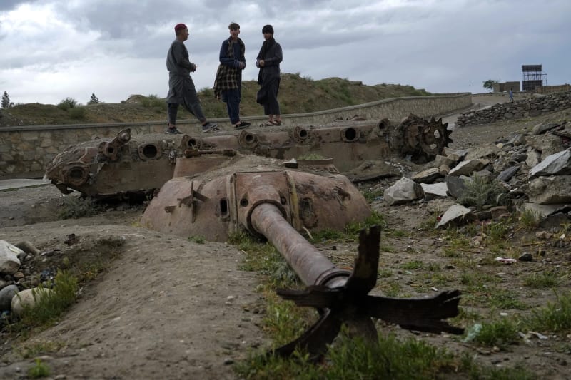Afghánští chlapci stojí nad starým zničeným sovětským tankem používaným během sovětské okupace v afghánském Kábulu, úterý 3. května 2022. 
