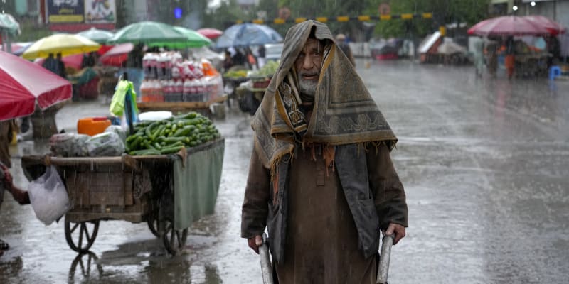 Afghánský dělník tlačí trakař během deštivého dne na starém trhu v Kábulu v Afghánistánu, úterý 3. května 2022. 