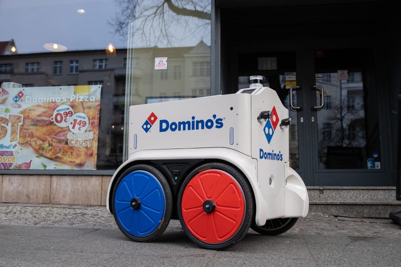 Robot rozvážející pizzu jede ulicí západní části Berlína.