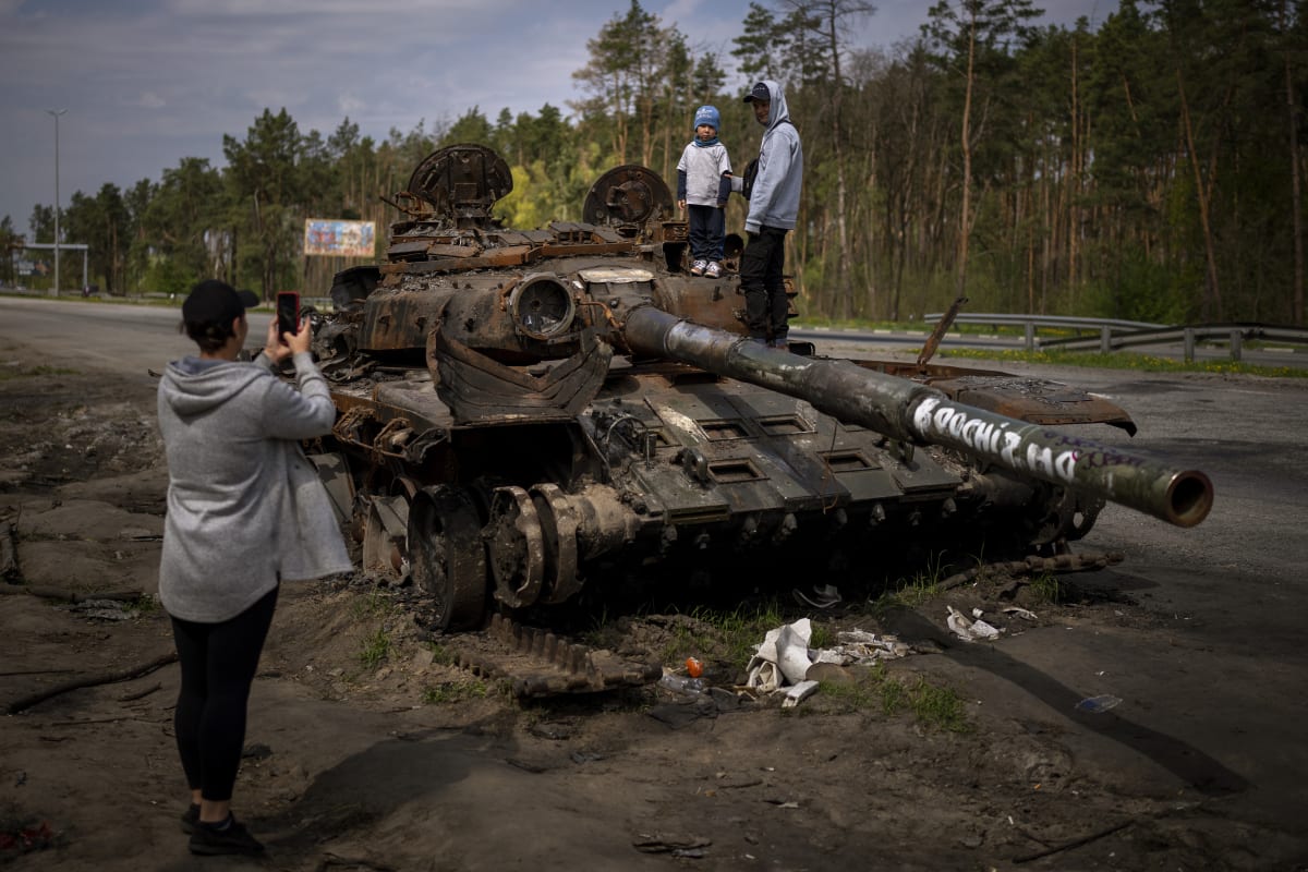 Děti se fotí na zničeném ruském tanku u Kyjeva.