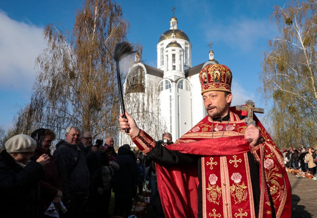 Pravoslavný kněz v ukrajinské Buči žehná obyvatelům města.