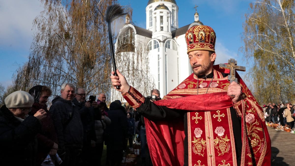 Pravoslavný kněz v ukrajinské Buči žehná obyvatelům města.