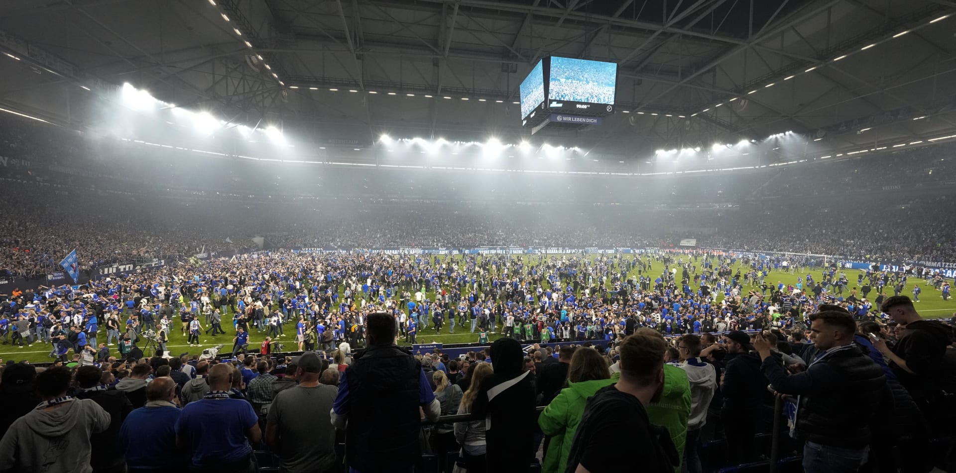 Fanoušci německého fotbalového klubu Schalke 04 zaplavili po vítězném utkání 3:2 nad FC St. Pauli ve druhé bundeslize na trávník Veltins Areny v Gelsenkirchenu téměř celé hřiště, aby oslavili postup do nejvyšší soutěže. Na tribunách však někteří lidé bojovali o život. 