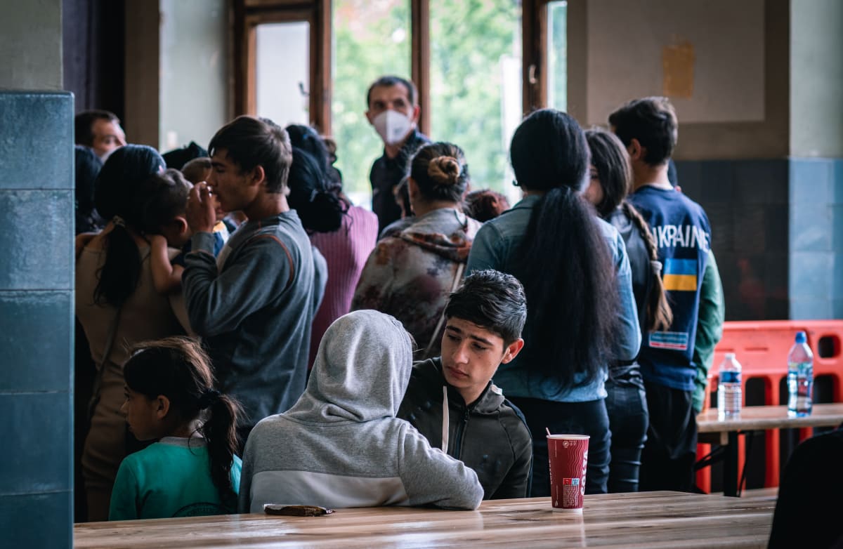 V registrační hale pro uprchlíky se nachází několik stolů a laviček, stany dobrovolníků i pultík s občerstvením. 