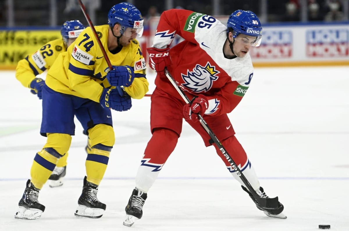 Český hokejista Matěj Blümel v souboji se švédským soupeřem na MS 2022.