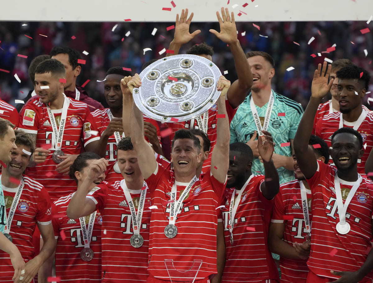 Polský útočník německého fotbalového klubu Bayern Mnichov Robert Lewandowski drží nad hlavou „mísu“ pro vítěze bundesligy ročníku 2021-2022.