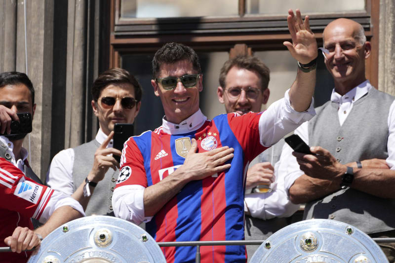 Polský útočník německého fotbalového klubu Bayern Mnichov Robert Lewandowski (uprostřed v brýlích) mává fanouškům z balkonu radnice na Mariánském náměstí v Mnichově, kde se den po skončení bundesligy uskutečnily oslavy desátého mistrovského titulu v řadě. 