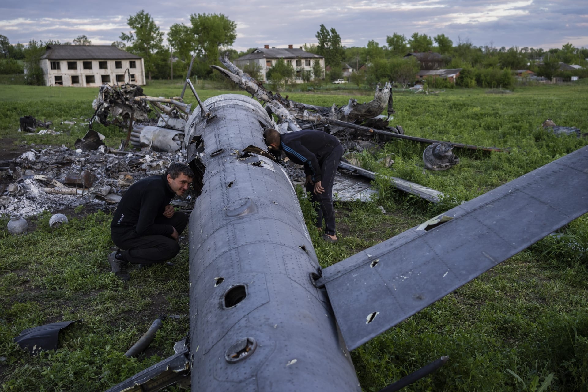 Muži zkoumají trosky sestřeleného ruského vrtulníku u vesnice Malaja Rohan v Charkovské oblasti.