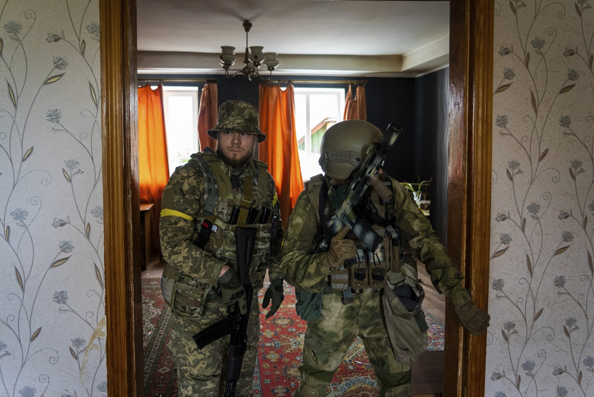 Ukrajinští vojáci během prohlídky bytu v jedné ze znovudobytých vesnic v Charkovské oblasti