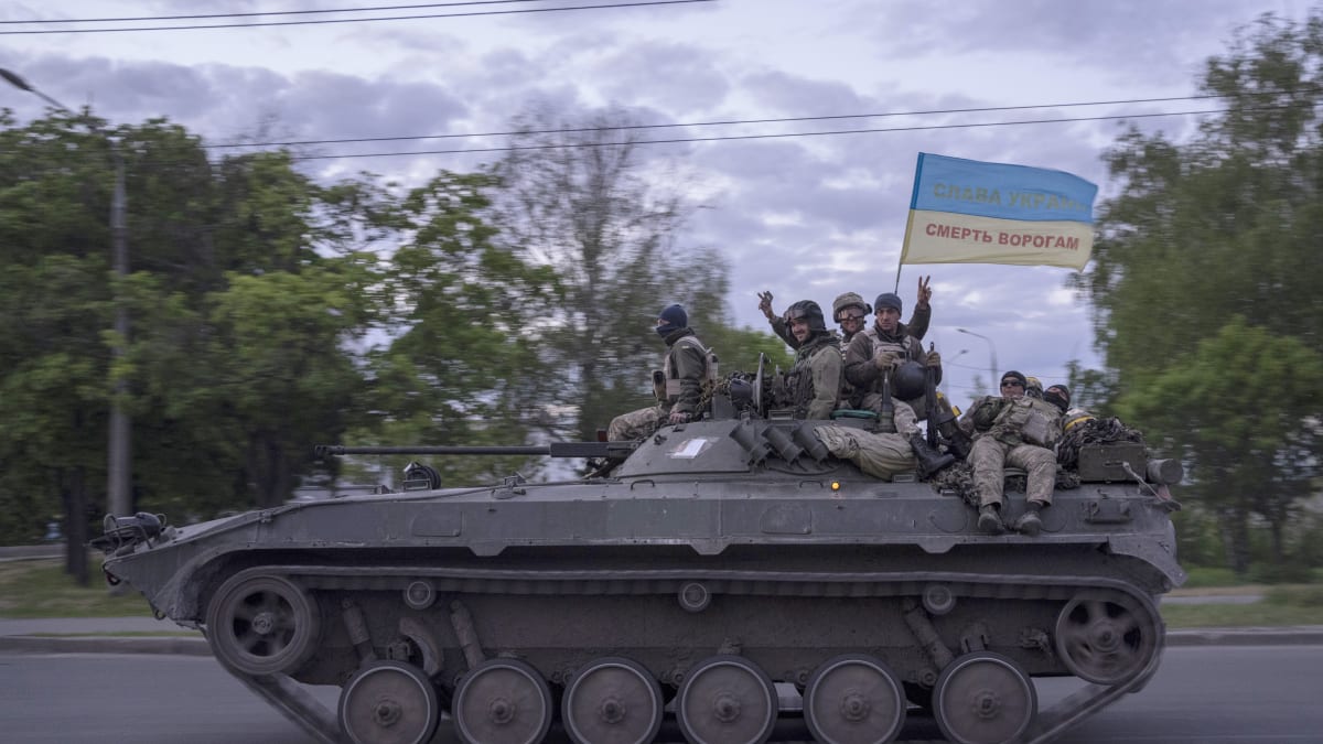 Ukrajinští vojáci v Charkovské oblasti. Na horní části vlajky stojí „Sláva Ukrajině“, na té spodní „Smrt nepřátelům“.