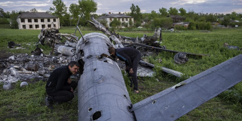 Muži zkoumají trosky sestřeleného ruského vrtulníku u vesnice Malaja Rohan v Charkovské oblasti.