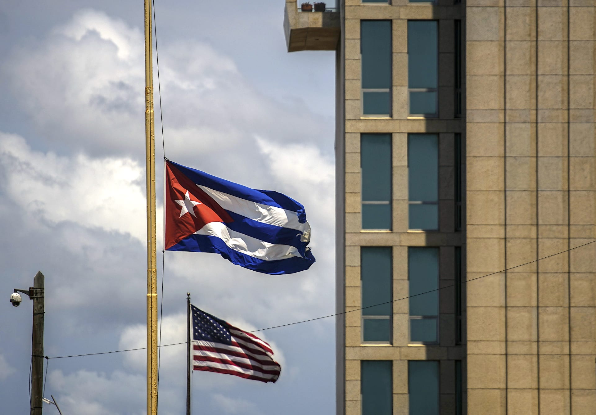 Kubánská vlajka vedle americké před americkým velvyslanectvím v Havaně. Administrativa prezidenta Joea Bidena v květnu 2022 oznámila, že zvýší počet letů na Kubu a zruší omezení z doby Donalda Trumpa týkající se převodů peněz, které mohou imigranti posílat lidem na ostrově.