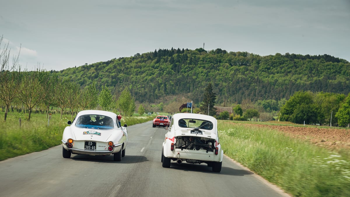 Klasický obrázek z Tour auto: Na venkovské silnici se pod plným plynem předhání 60 let staré sporťáky, v tomto případě Alfa Romeo Giulia S.S. a Fiat 600 Abarth.Fiat