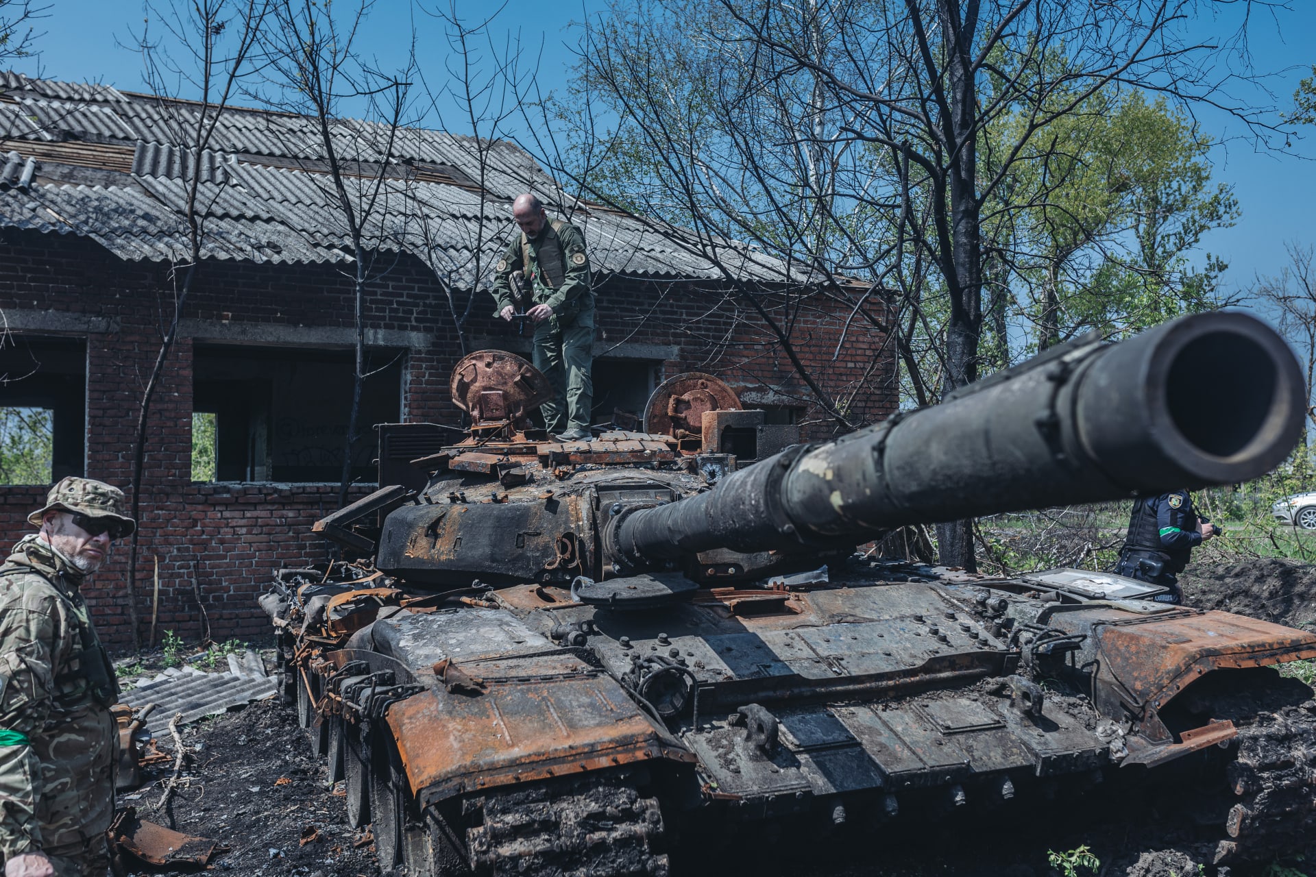 Ukrajinští vojáci u zničeného ruského tanku na předměstí Charkova, 8. května 2022