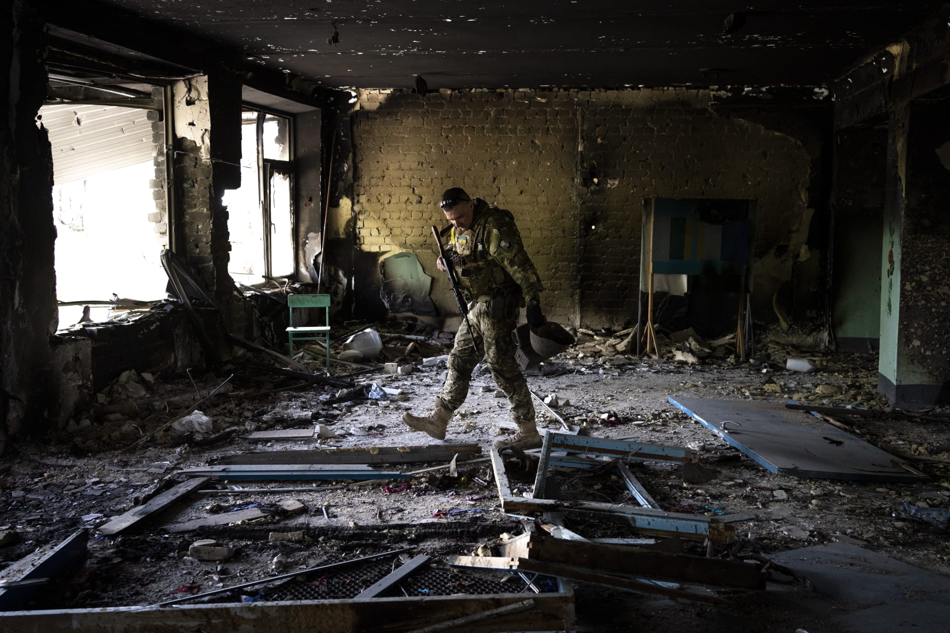 Ukrajinský voják prohlíží zničenou školu ve městě Vilchivka nedaleko Charkova