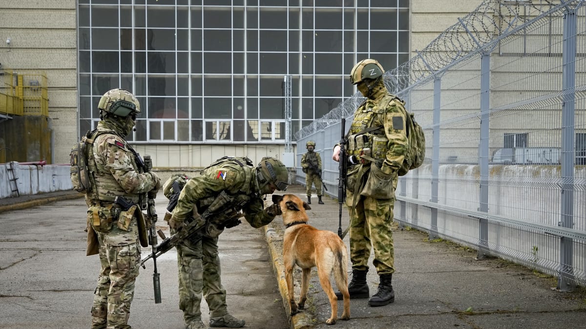 Ruští vojáci před vstupem do Kachovské vodní elektrárny na řece Dněpr v Chersonské oblasti