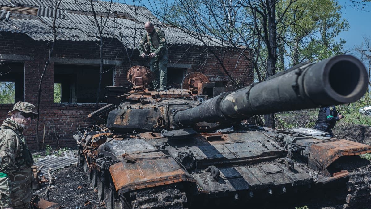 Ukrajinští vojáci u zničeného ruského tanku na předměstí Charkova, Ukrajina, 8. května 2022.