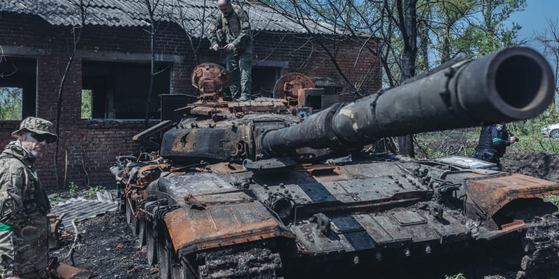 Ukrajinští vojáci u zničeného ruského tanku na předměstí Charkova, 8. května 2022