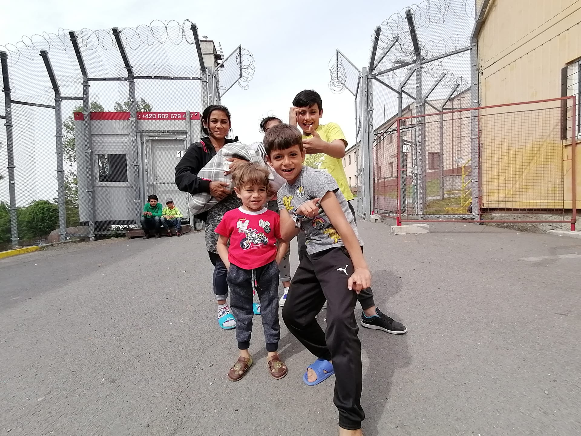 Uprchlický tábor ve Vyšních Lhotách. Brána do areálu a v ní rodina Lakatošů z Užhorodu.