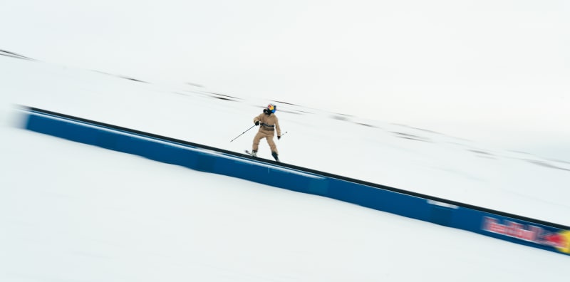 Švédský freestylový lyžař Jesper Tjäder jede bokem vstříc novému světovému rekordu v délce sjezdu railu na lyžích. Ve středisku v re na kovové trubce ujel 154,49 metru.