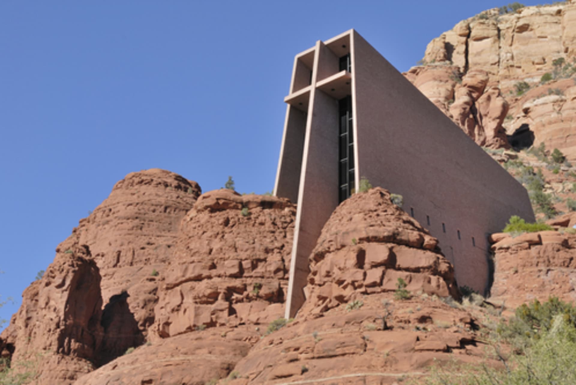 Moderní kostel díky hranatému tvaru a barevným oknům nádherně vyniká proti pískovcovým skalám - Arizona, USA