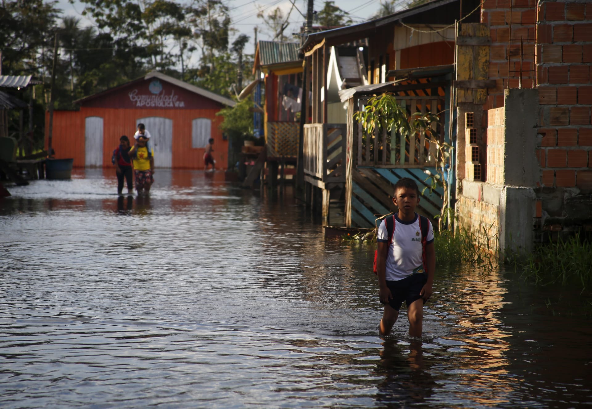 Žák jde do školy po ulici zaplavené stoupající hladinou řeky Negro v Irandubě v brazilském státě Amazonas. Snímek z pondělí 23. května 2022. 