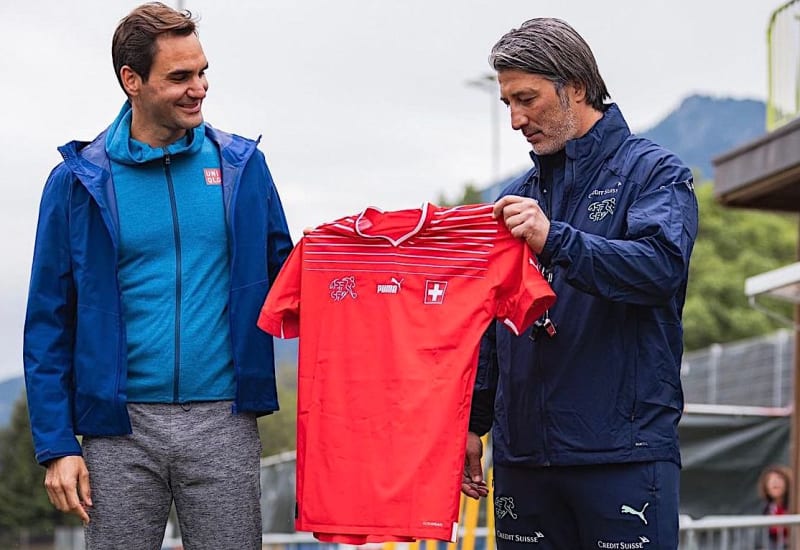 Tenista Roger Federer (vlevo) přebírá od trenéra švýcarské fotbalové reprezentace Murata Yakina dres během soustředění v Bad Ragazu před zápasem Ligy národů v Praze proti Česku. 